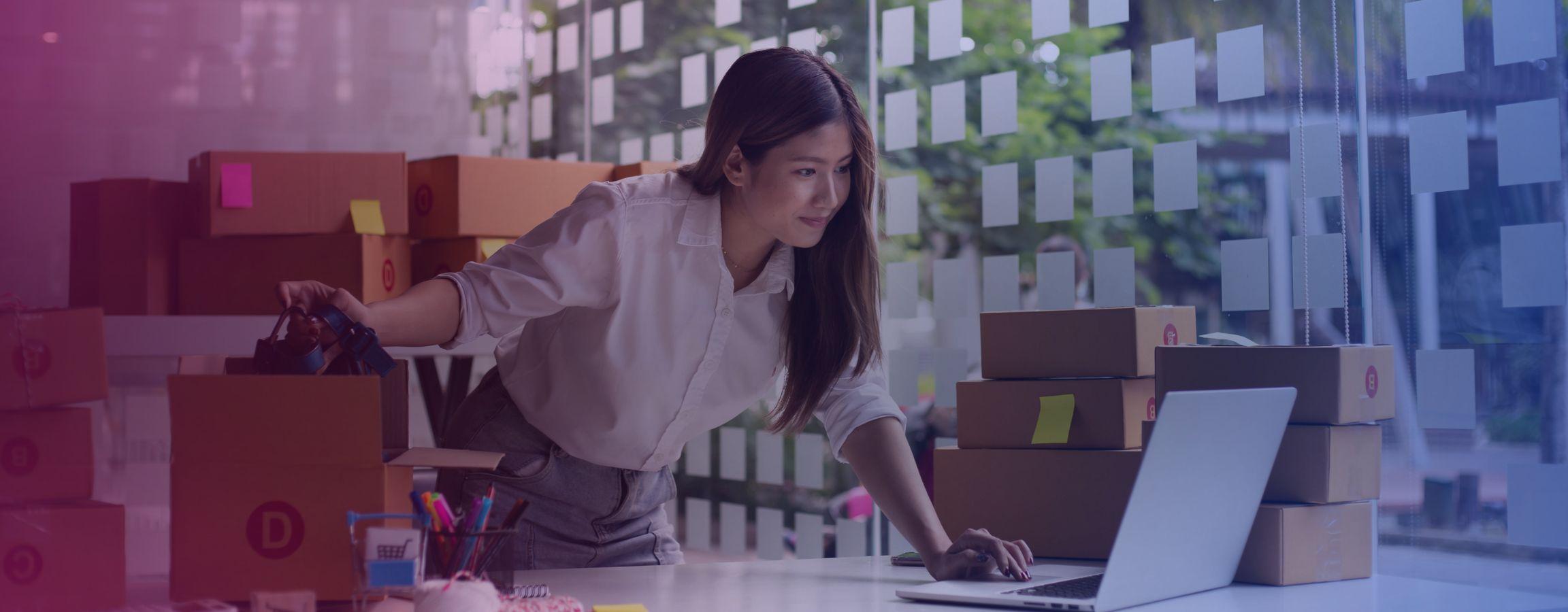 stock image of businesswoman packaging boxes