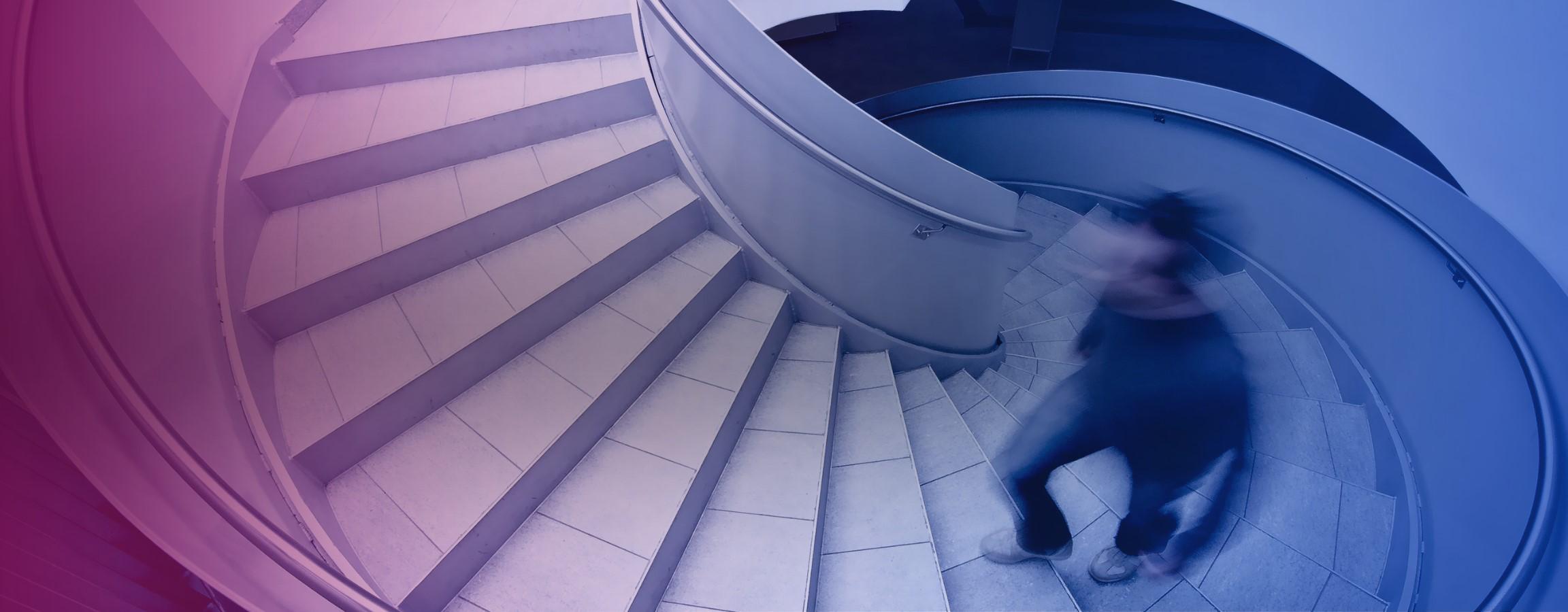 Stock image of someone walking up a spiral staircase