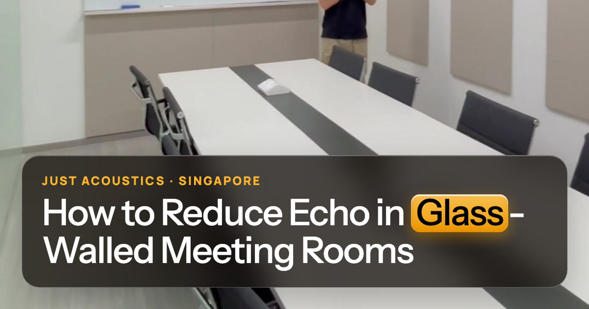 Glass-walled meeting room with acoustic panels on the solid wall