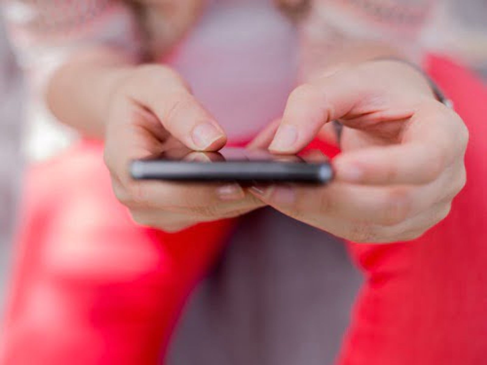 Child's hands holding and using a mobile device or smartphone.