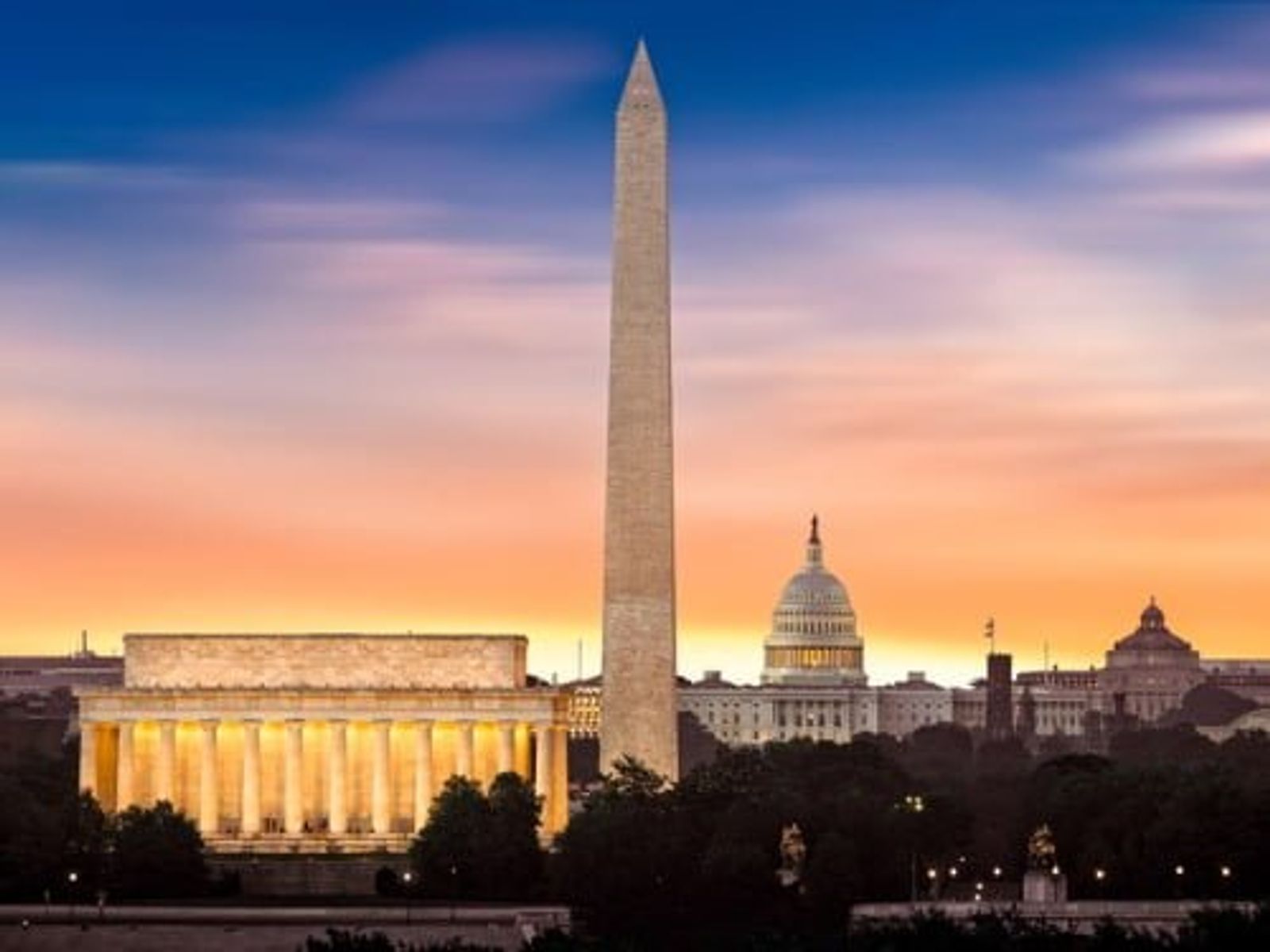 Washington DC monuments at sunset: Lincoln Memorial, Washington Monument, and Capitol Building illuminated.