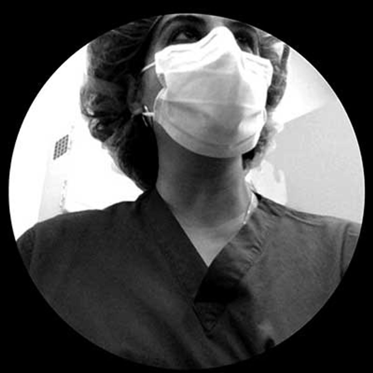 Black and white photograph of person wearing protective face mask, looking upward.