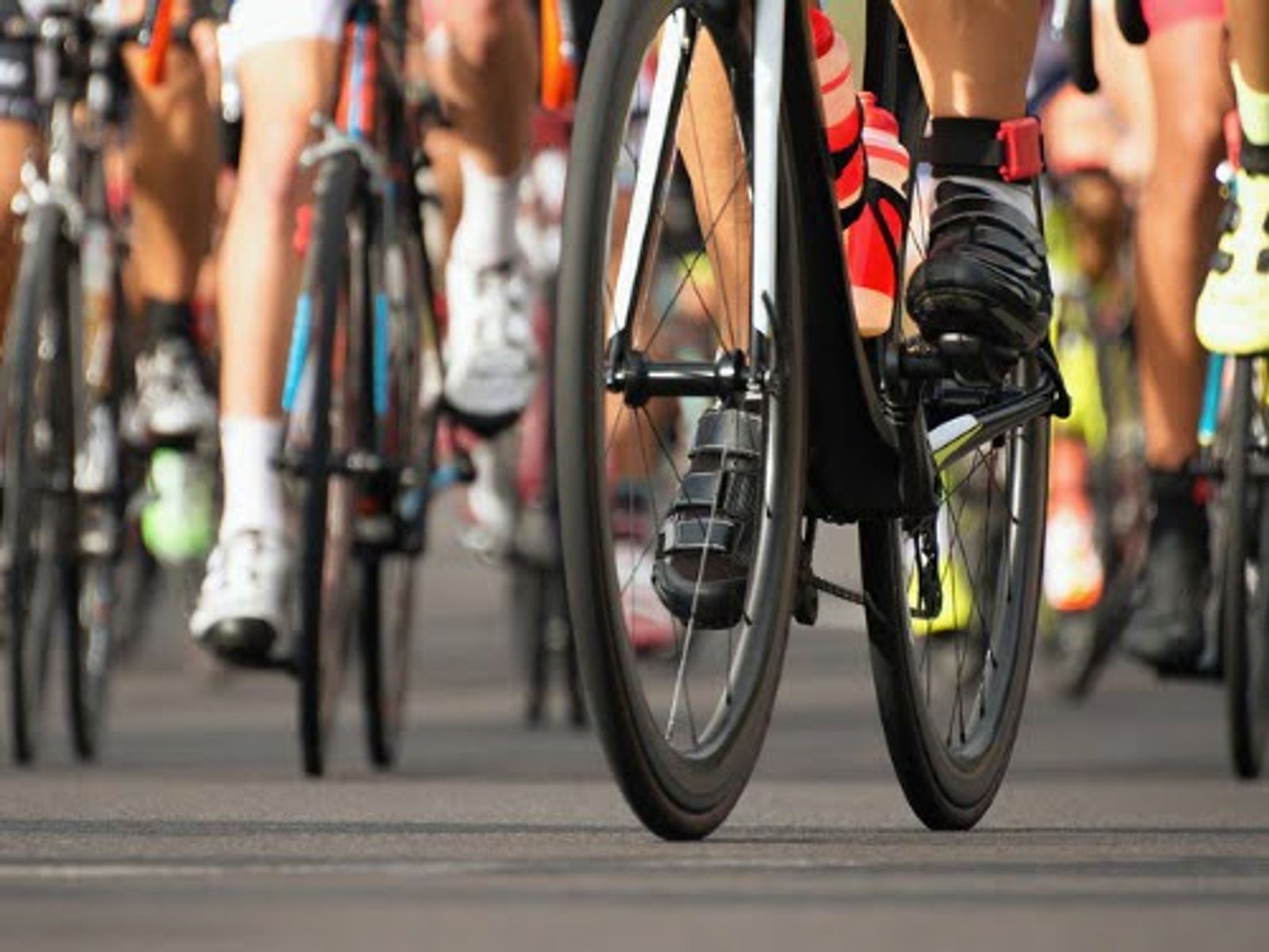Multiple cyclists riding road bikes in a group event or race.