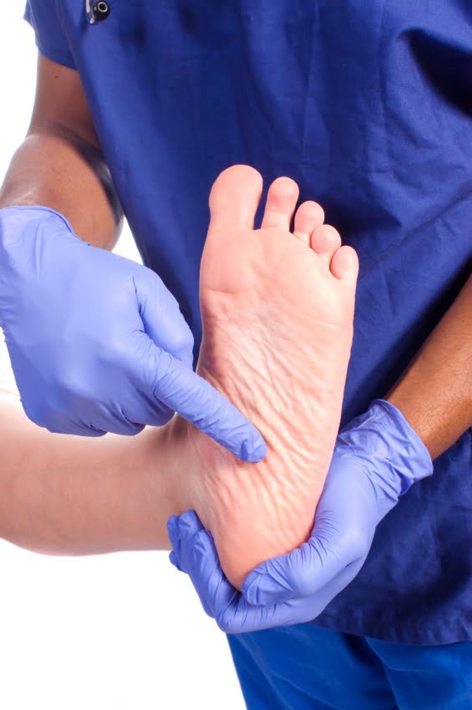 Healthcare professional in blue gloves examining infant's foot during medical checkup.