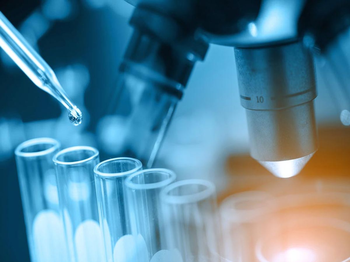 Pipeta de laboratorio dispensando líquido en tubos de ensayo en un entorno de investigación científica.