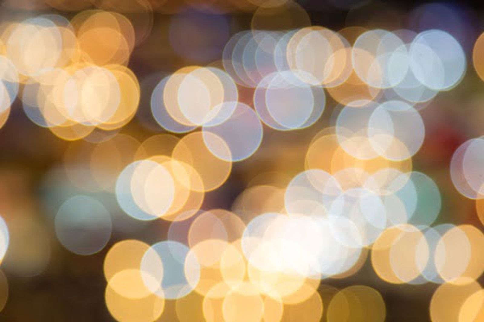 Blurred bokeh lights in warm gold, white, and cool blue tones creating an out-of-focus background.