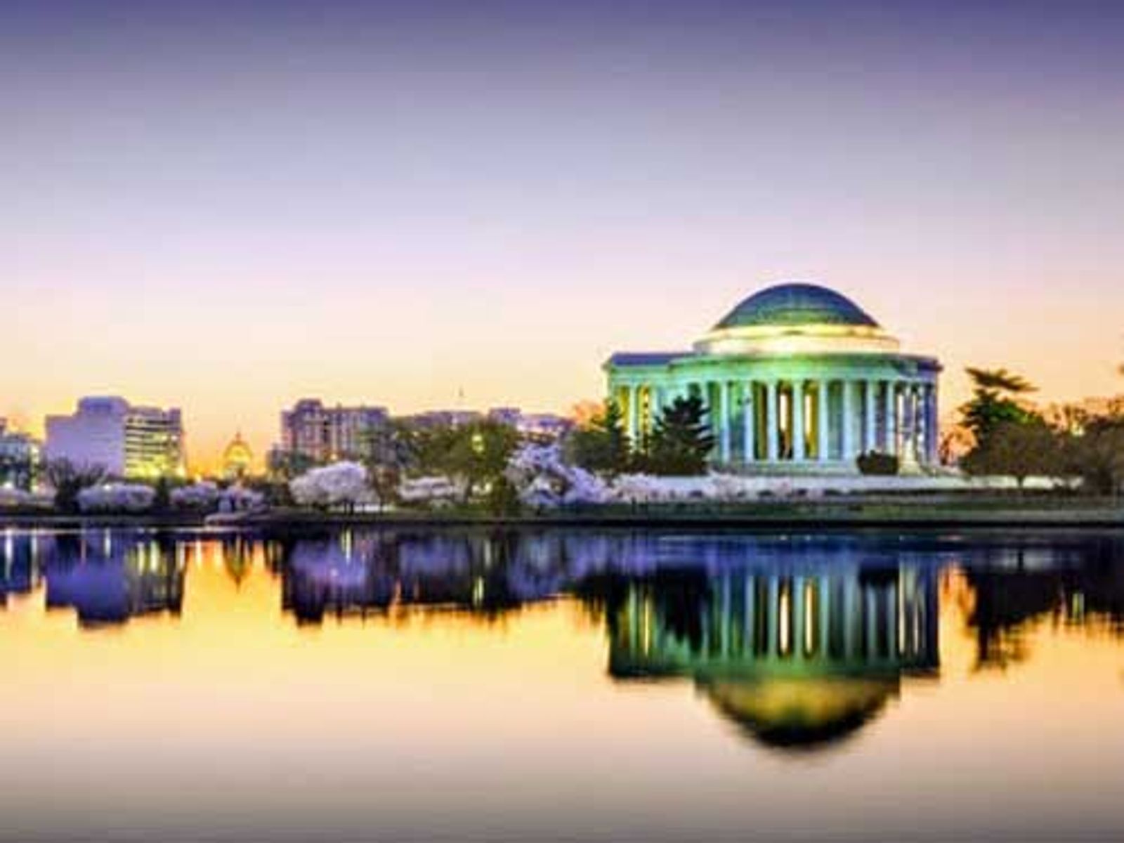 Jefferson Memorial reflected in Tidal Basin at sunrise, Washington DC skyline.
