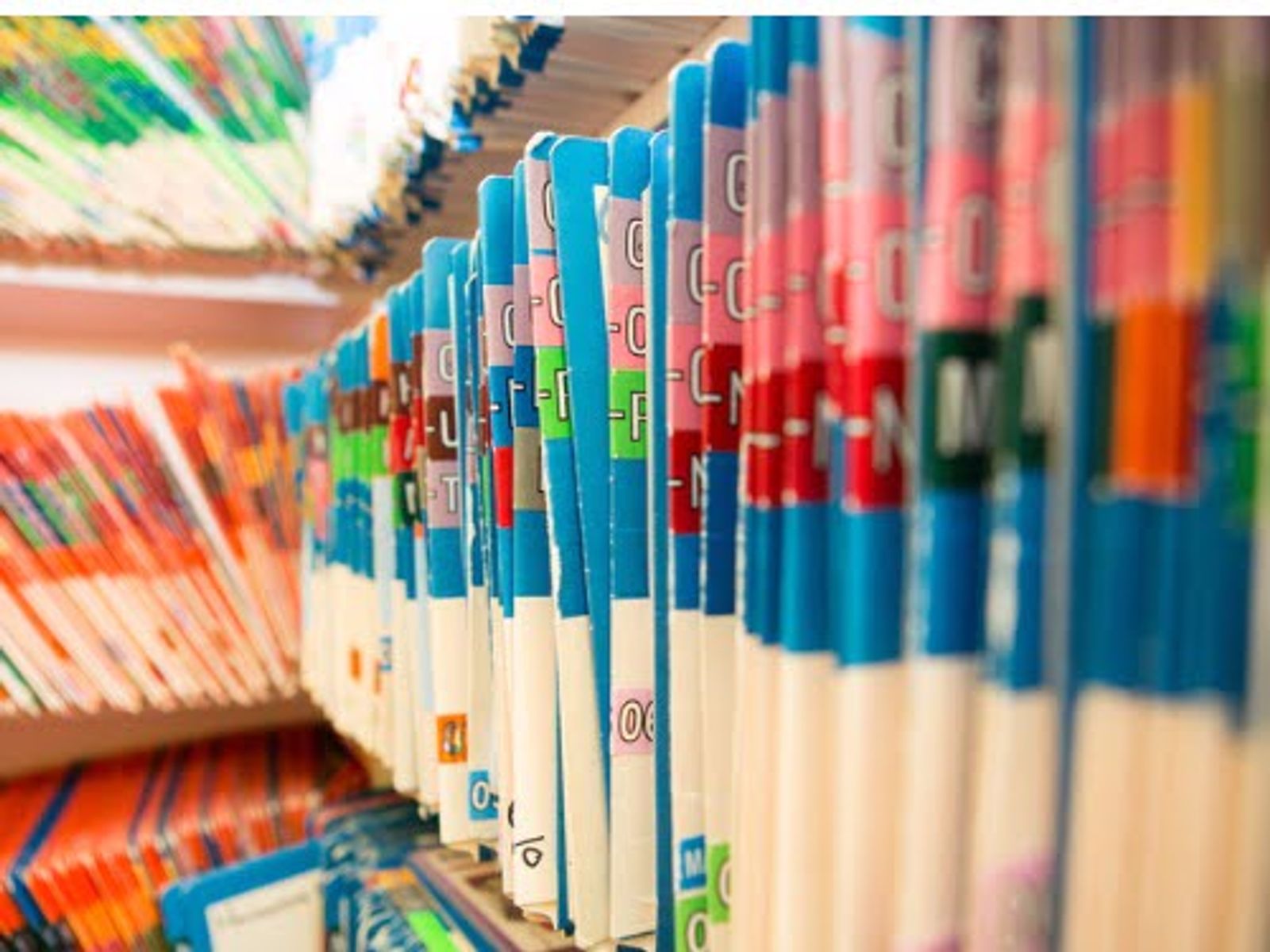 Row of colorful DVD cases arranged on shelf with blue and white spines visible.