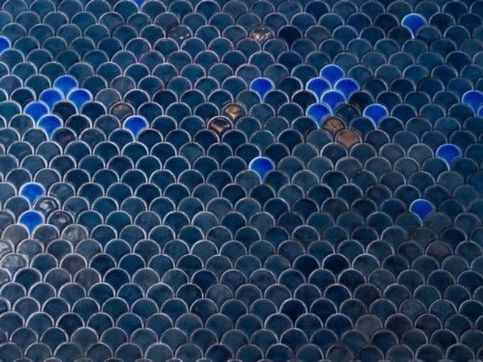 Fish scale pattern tiles in blue and gray with scattered bright blue accents