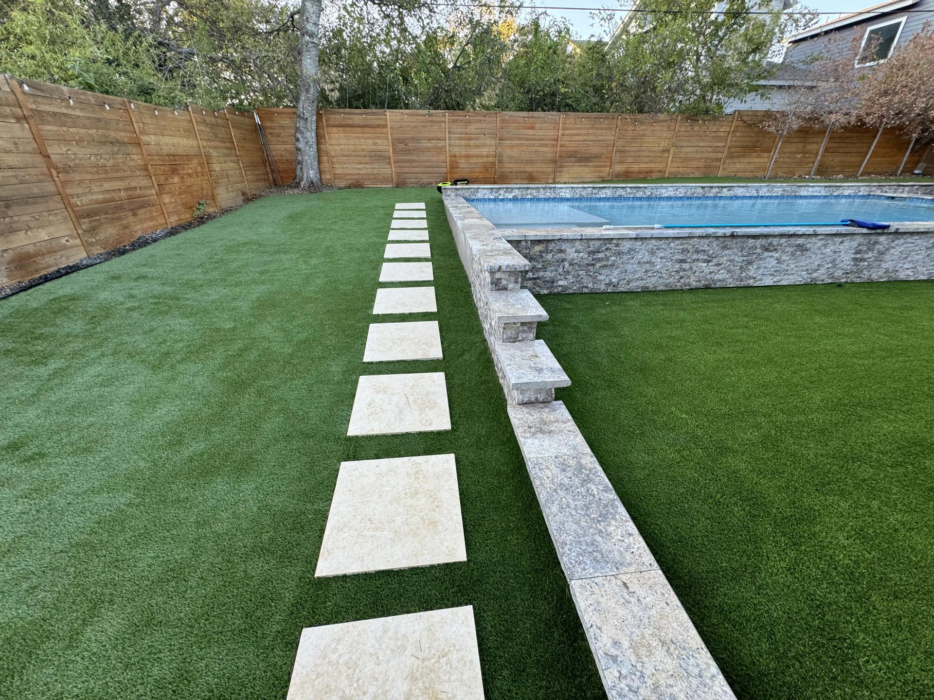 Artificial turf around a modern backyard design