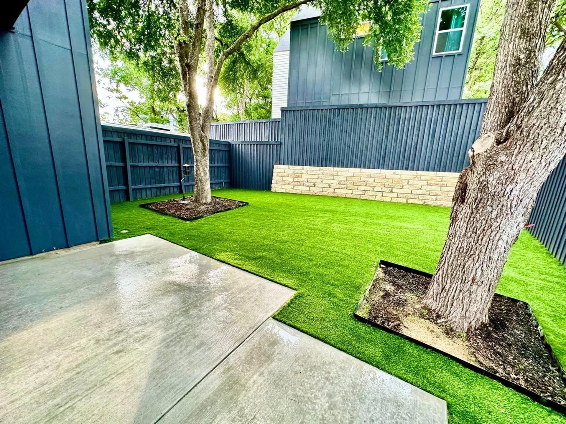 Black and white house with artificial turf in front yard