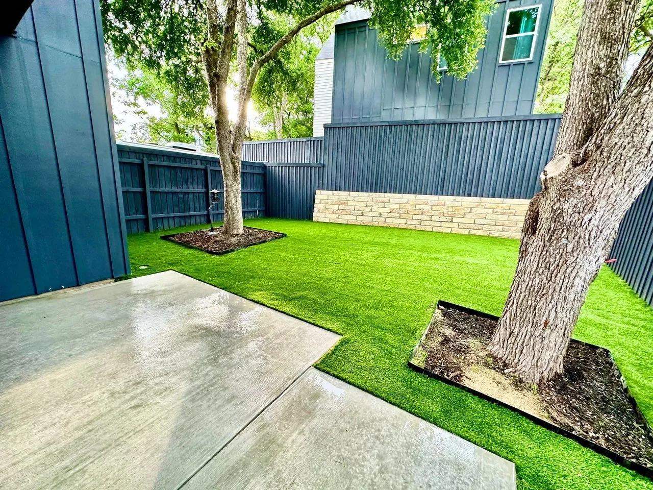 Black and white house with artificial turf in front yard
