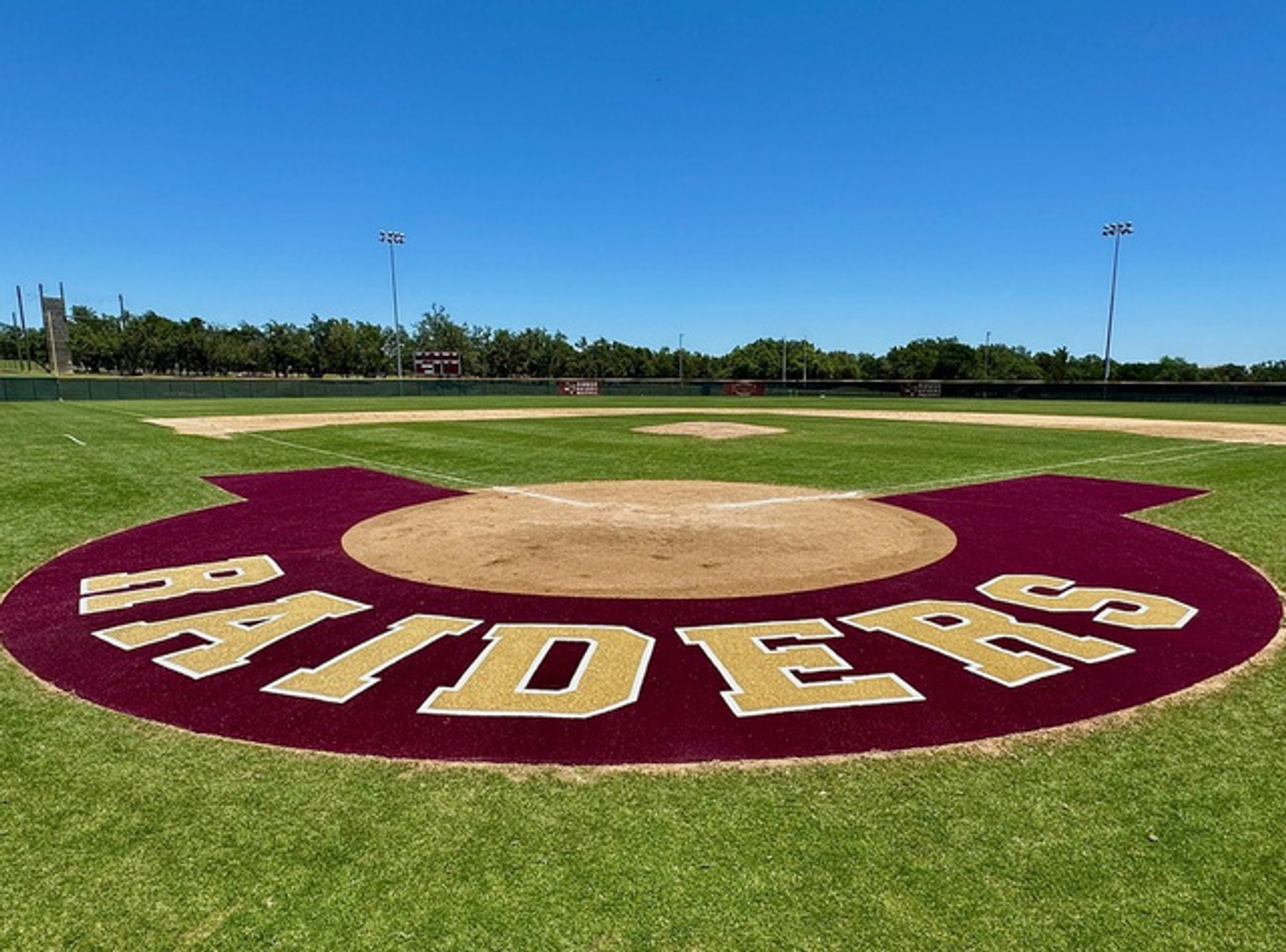 Rouse High School Raiders baseball infield with a custom turf logo