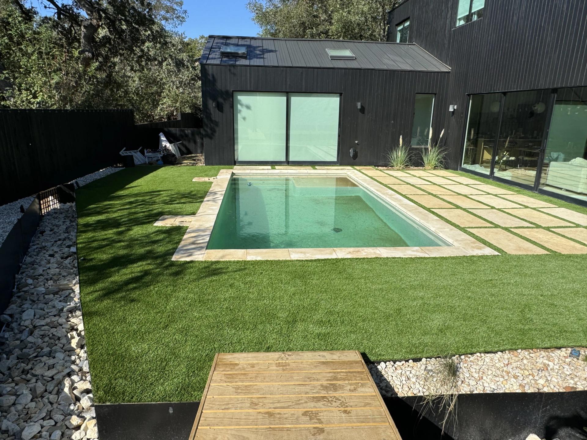 Artificial turf surrounding a backyard pool