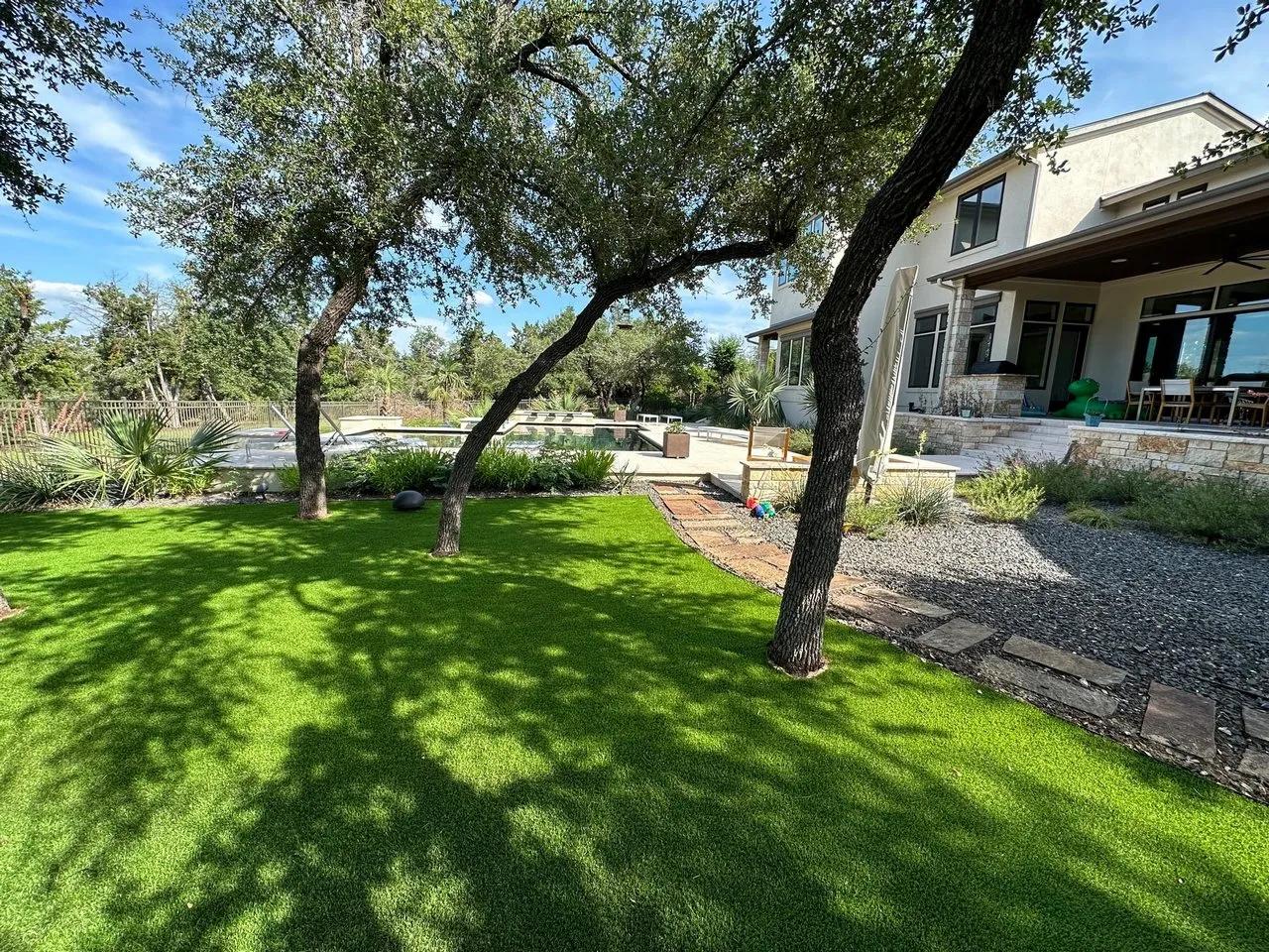 Trees within artificial turf and pool in the background