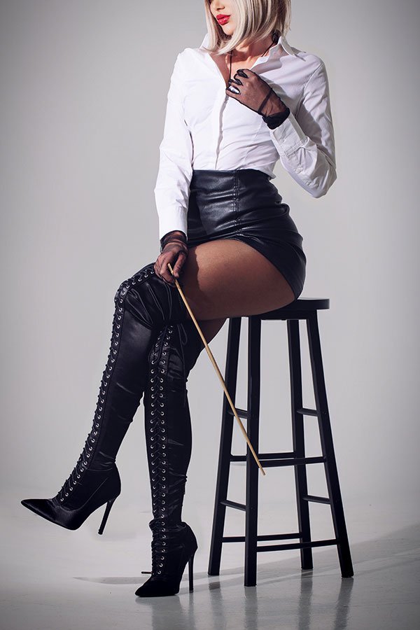 Strenge Herrin mit Rohrstock auf Barhocker - Disziplin, Sadismus und Schmerz in NRW.