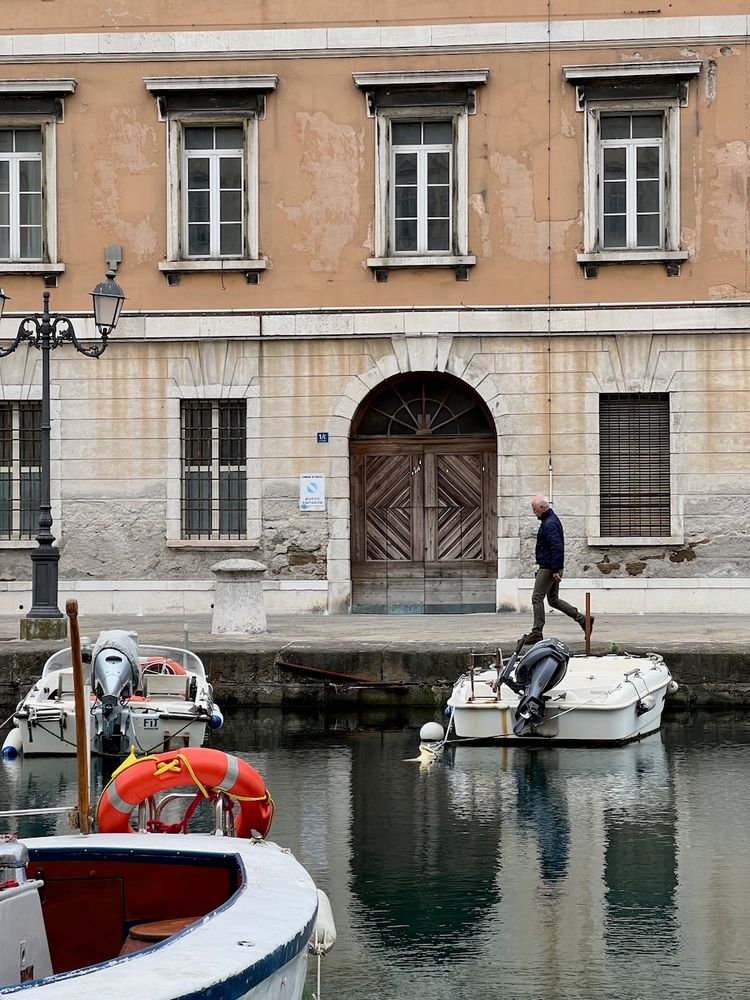 man walking along canal