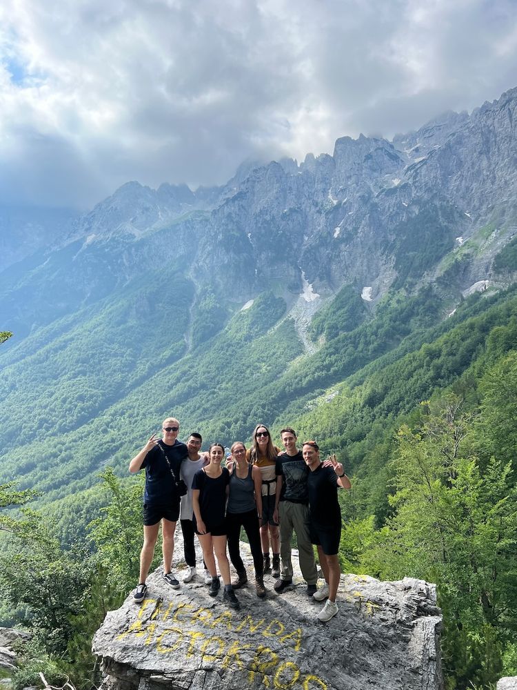 group photo on rock with mountains behind