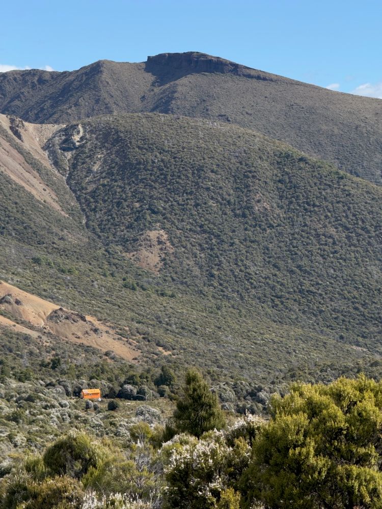 mountain hut dwarfed by mountain