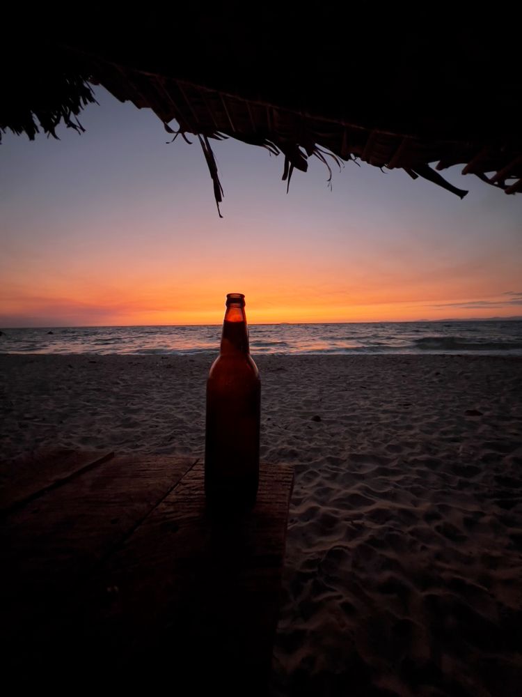 beer on beach at sunset