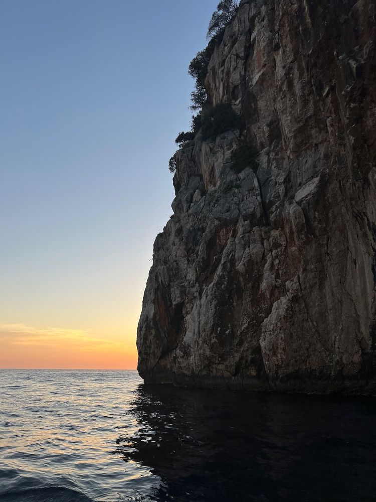 sun setting behind cliff