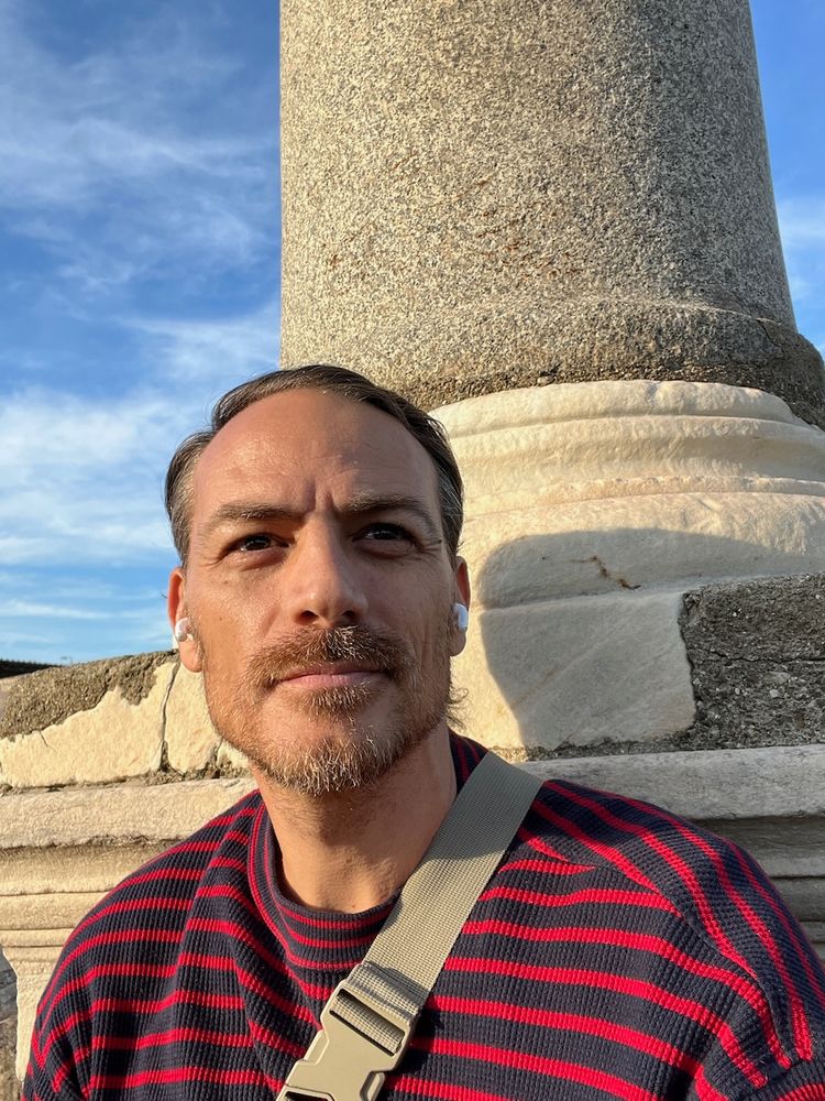 man taking selfie under ancient ruins