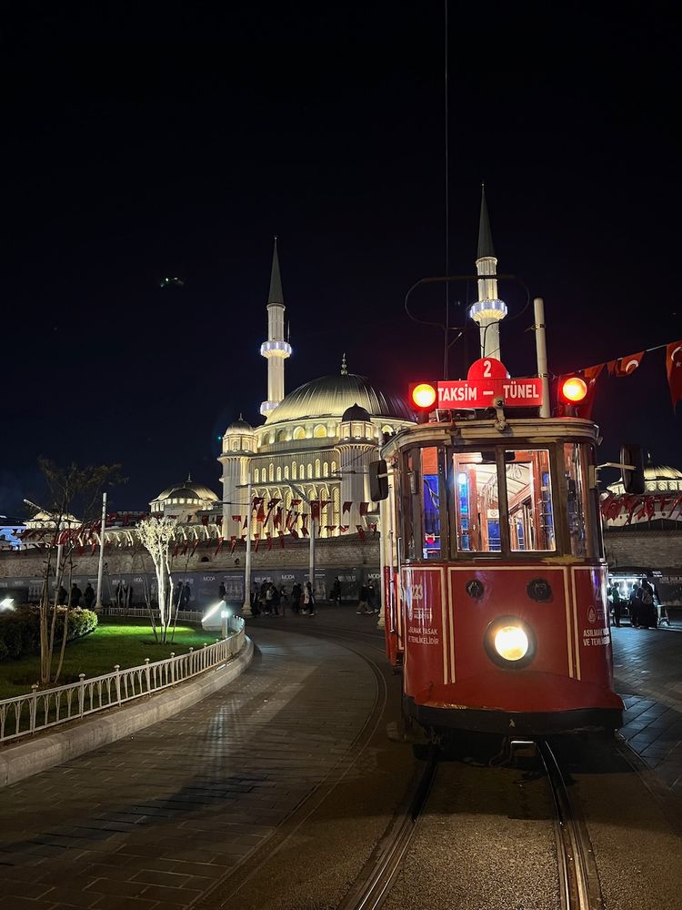 street tram at night with mosque in background