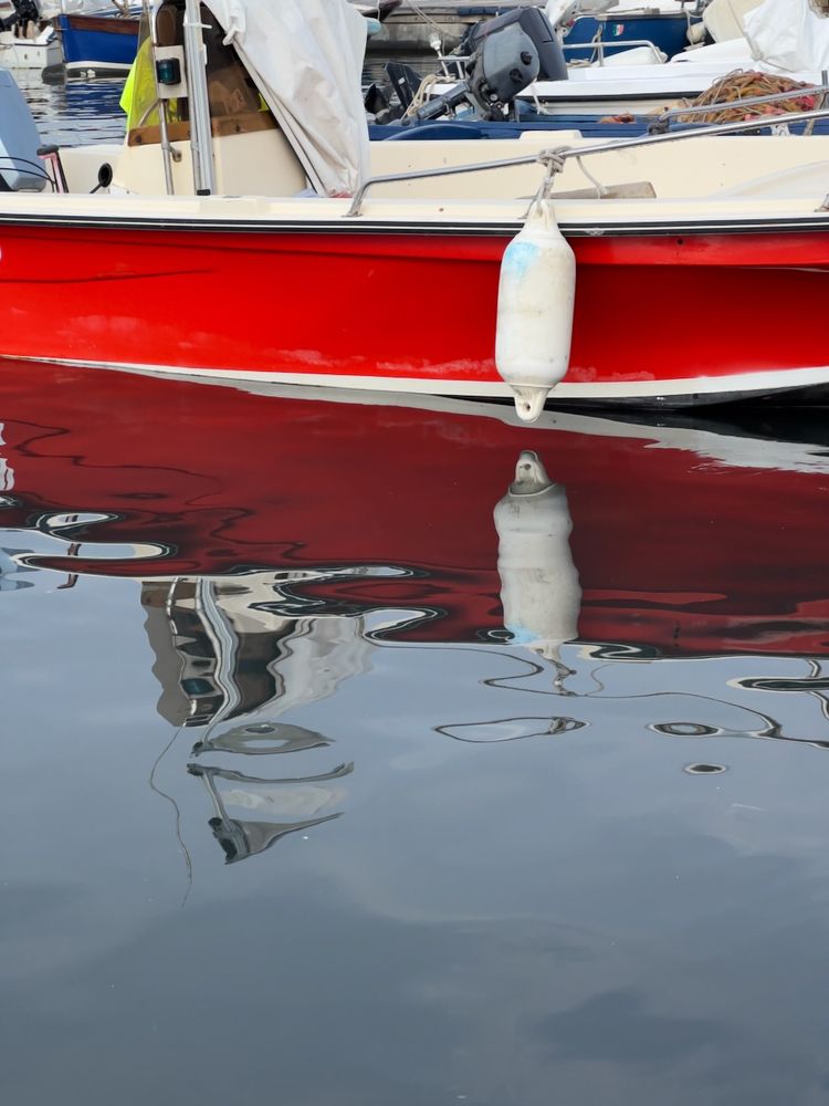 red boat reflecting in water