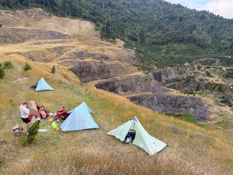 people camping on the edge of an abandoned quarry