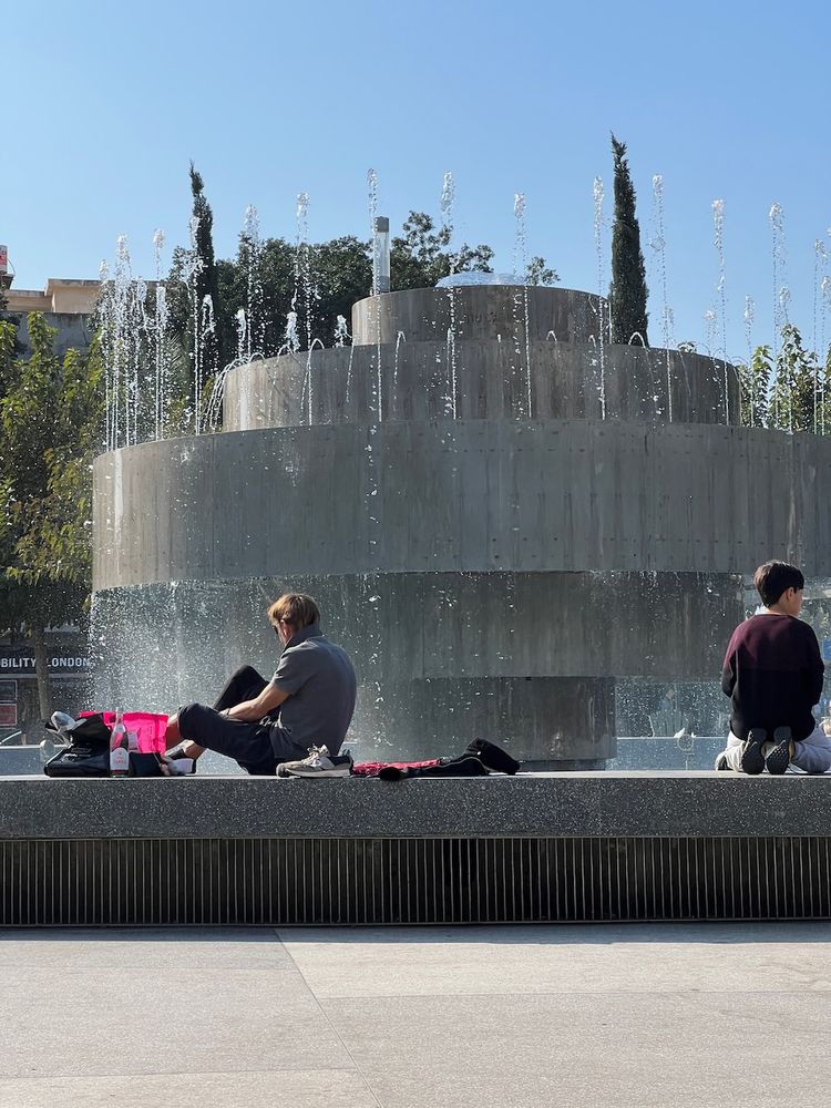 people sitting near fountain