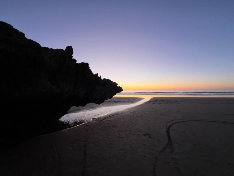 beach rock silhouettte at sunset