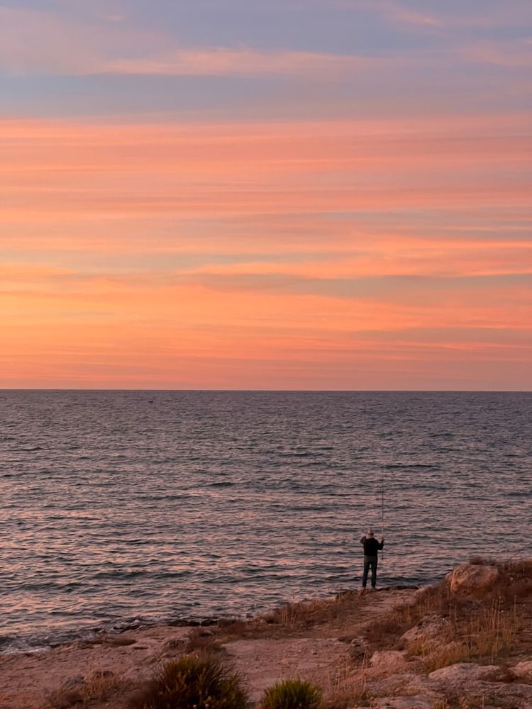 man fishing at sunset