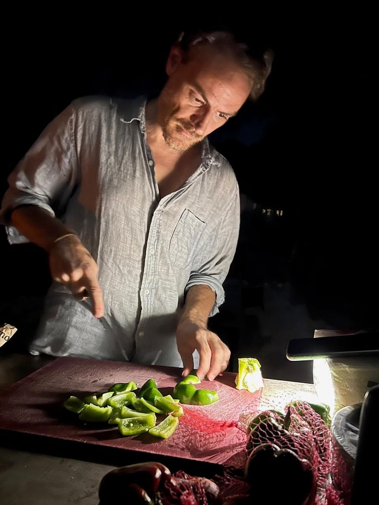 man cooking by flashlight