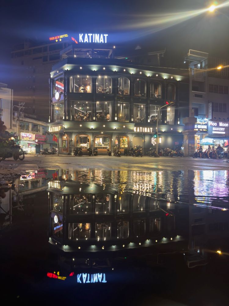 brightly lit building in reflection at night