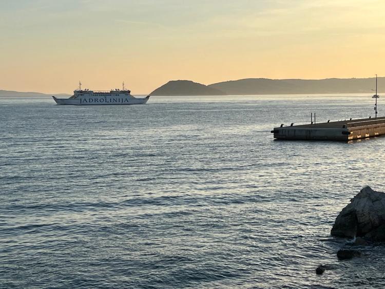 ferry leaving harbor at sunset