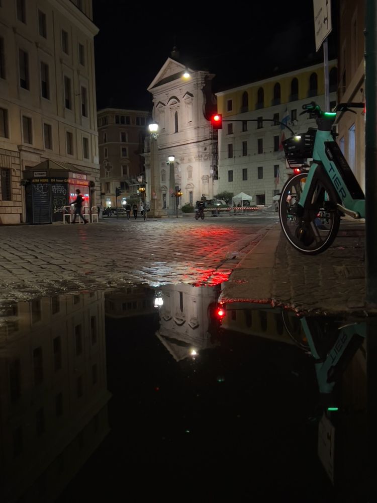building reflection in puddle at night