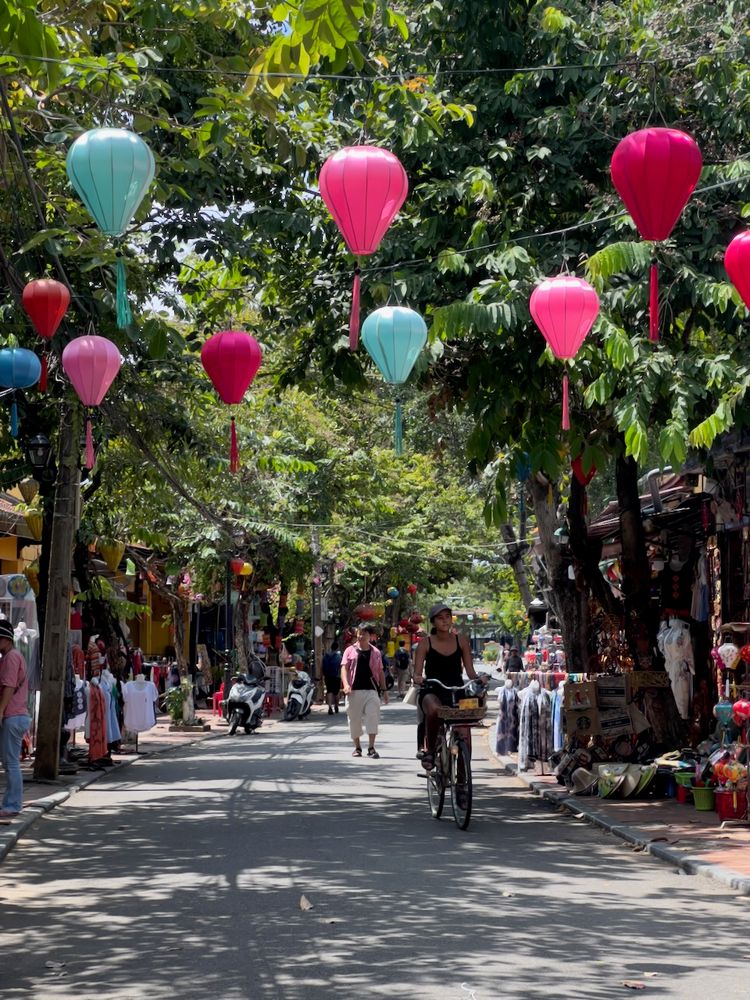 woman biking down colorful street