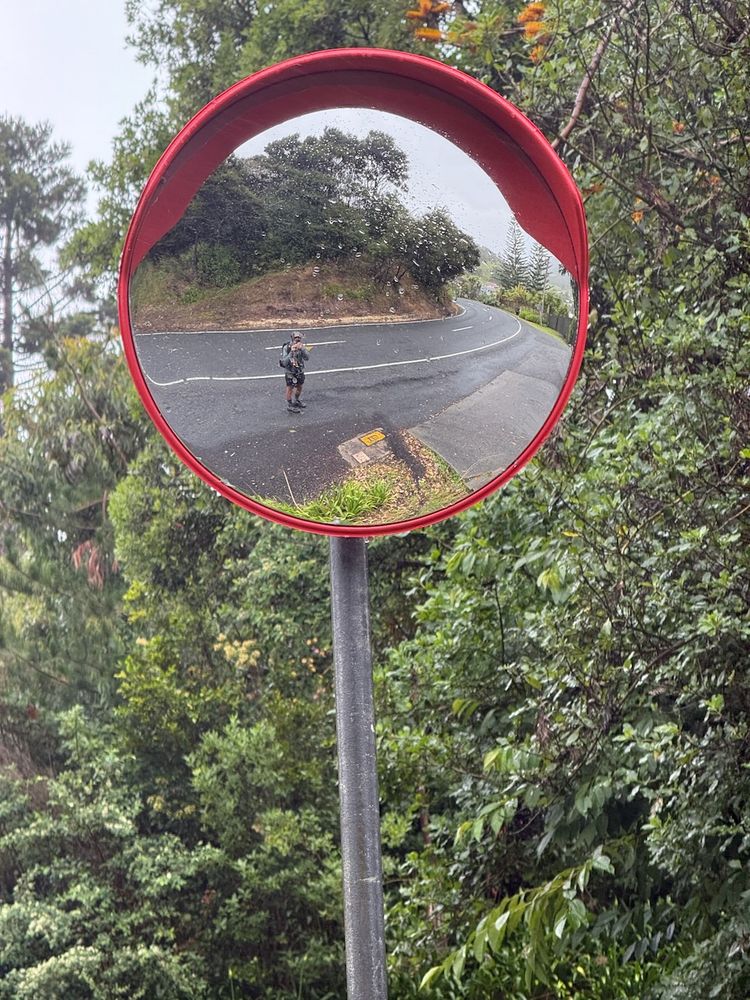 hiker taking mirror reflection photo in rain