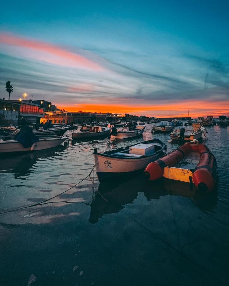 small boats in harbor at sunset