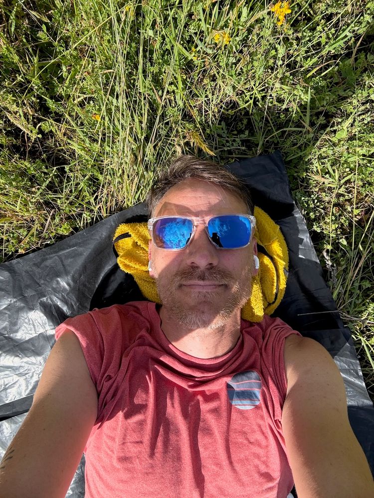 man laying in grass on sunny day