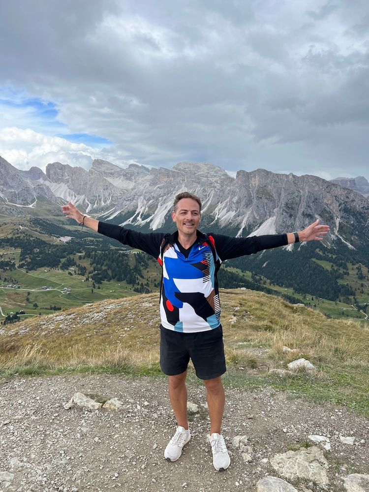 man with arms stretch with mountains behind