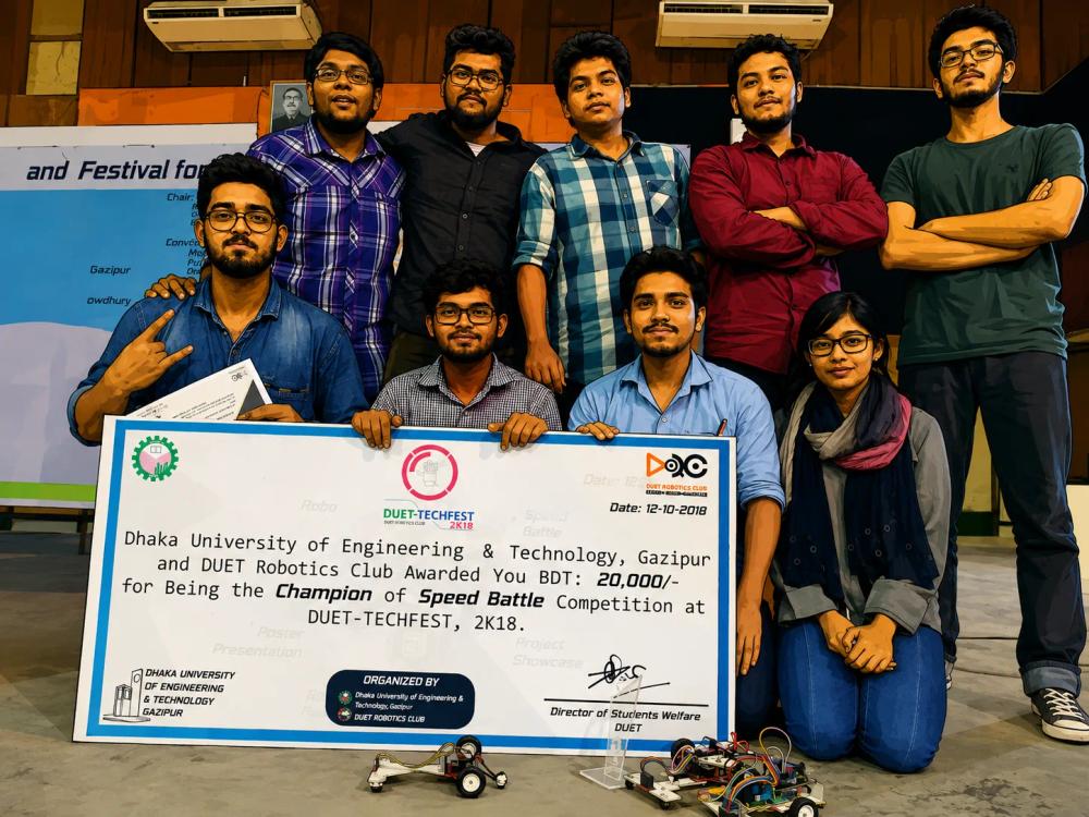 Adnan's team holding their winning prize at the DUET line-follower competition, 2018.