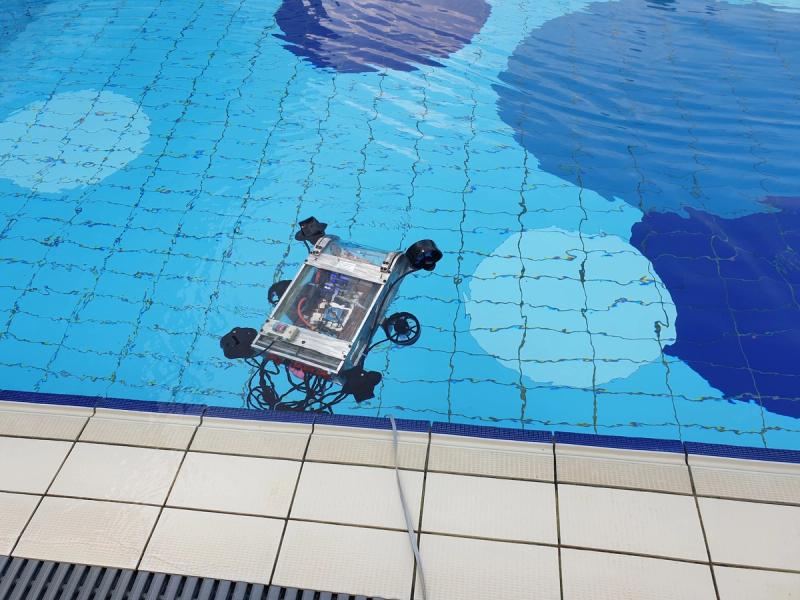 Duburi 2 floating just below the surface of the test pool during SAUVC 2019, tether trailing to shore.