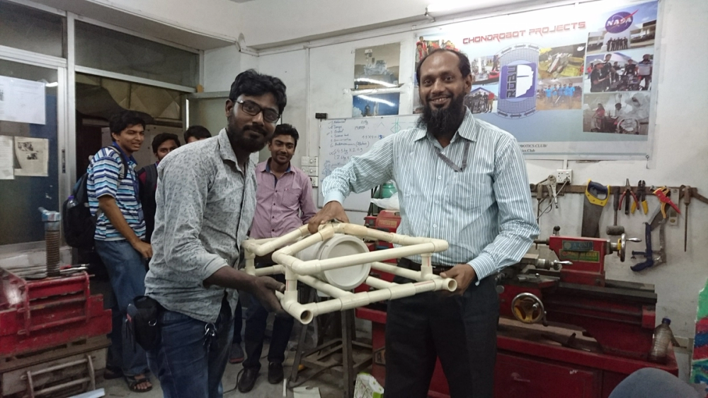 Munir Bhai and Dr. Khalilur Rahman holding the PVC pipe skeleton structure in the mechanical lab