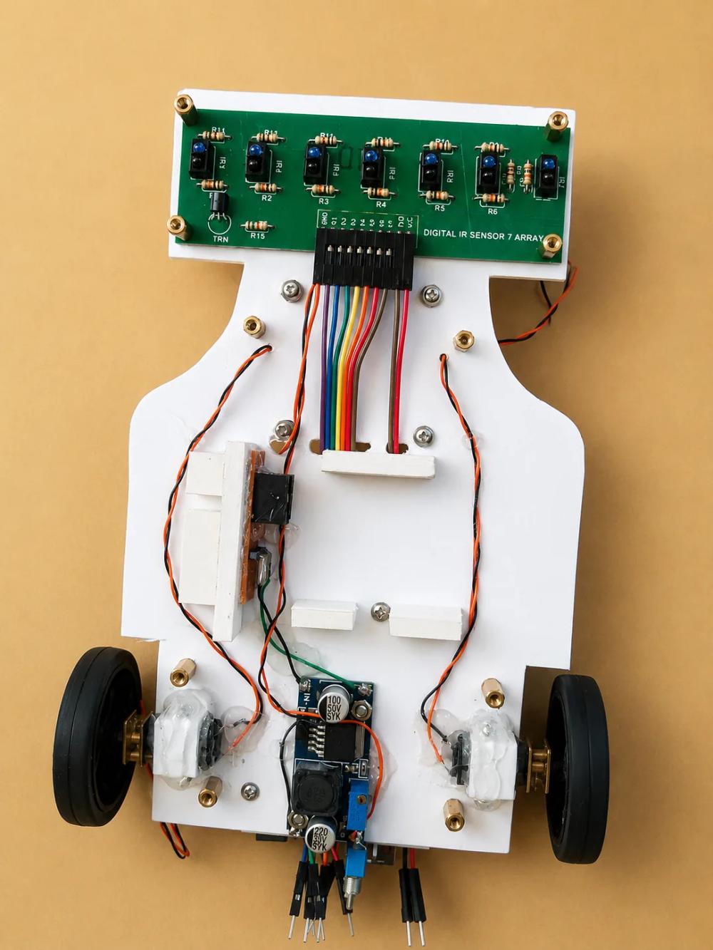 A white line-follower robot with a green infrared sensor array and two wheels.