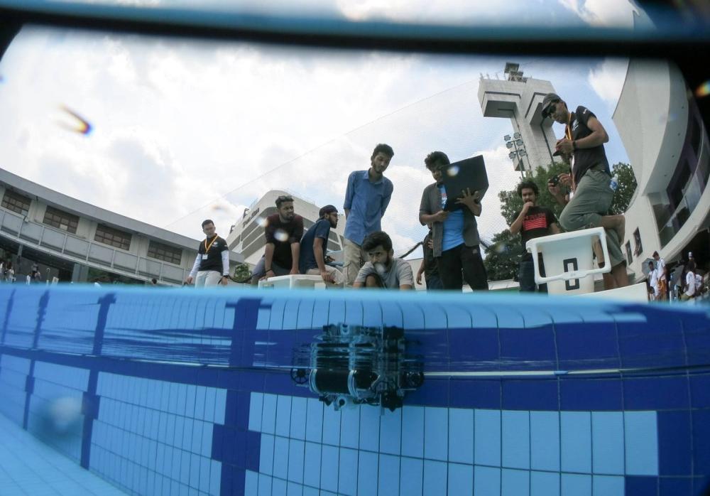 Duburi 2 submerged in the SAUVC 2019 qualifying-round pool while the team watches from the poolside above.