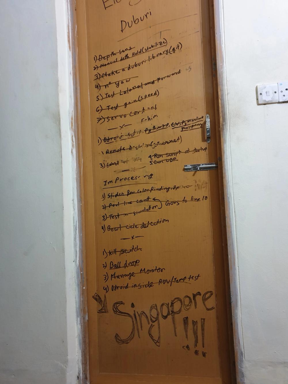 Adnan's handwritten Duburi task checklist and "Singapore" scrawled on his bathroom door before flying out.