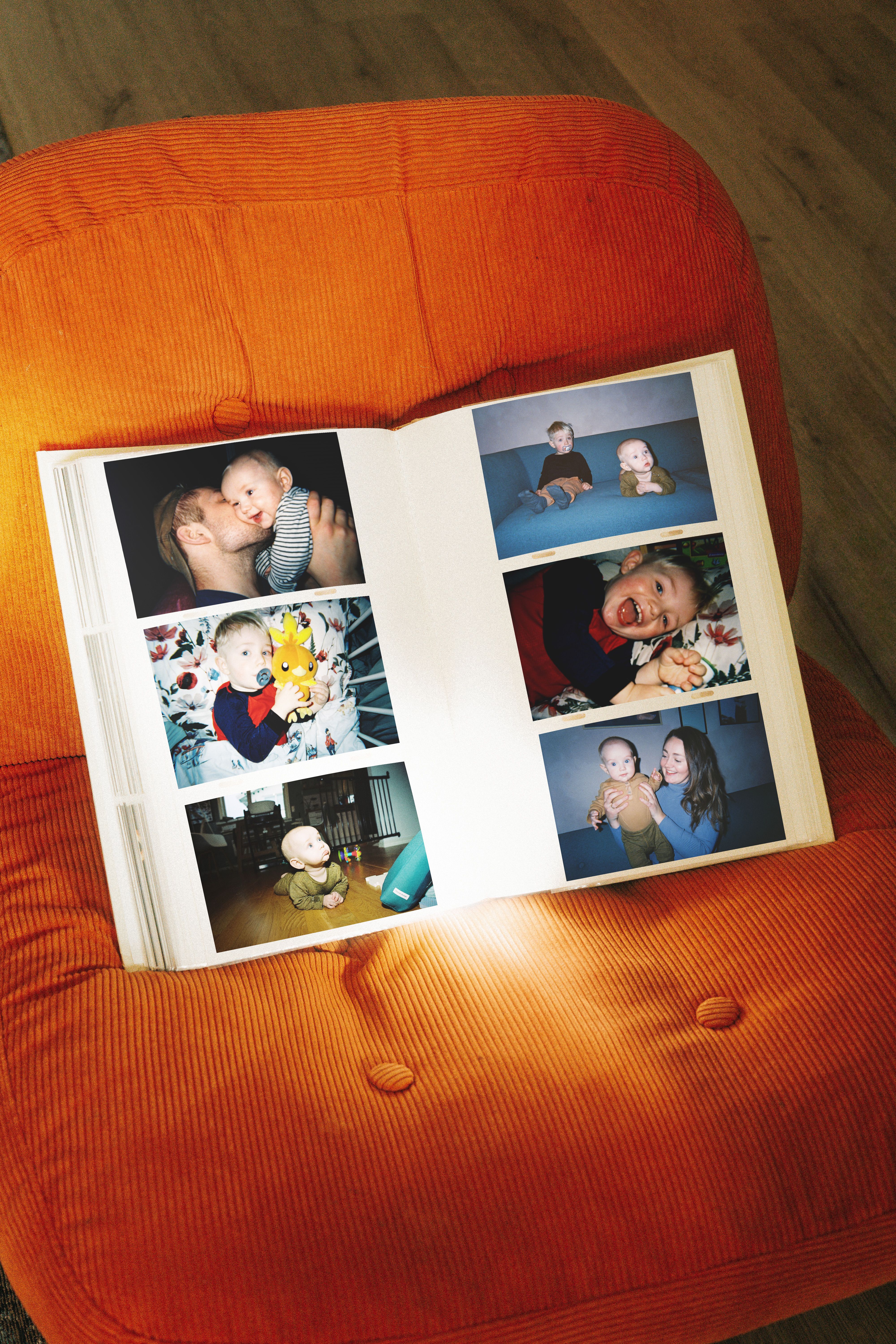 album med barnebilder på en oransje stol