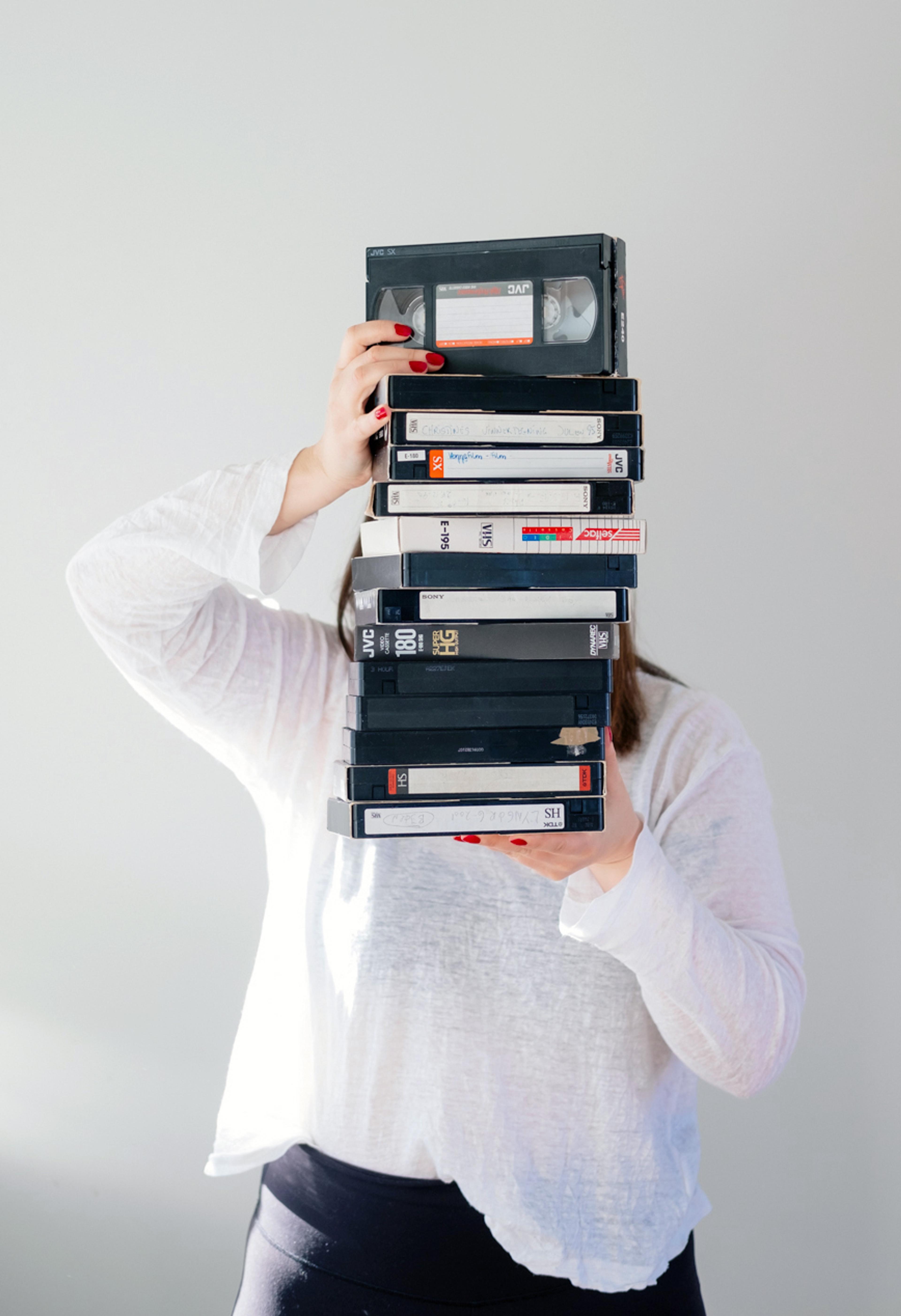 en dame som holder mange video kasetter