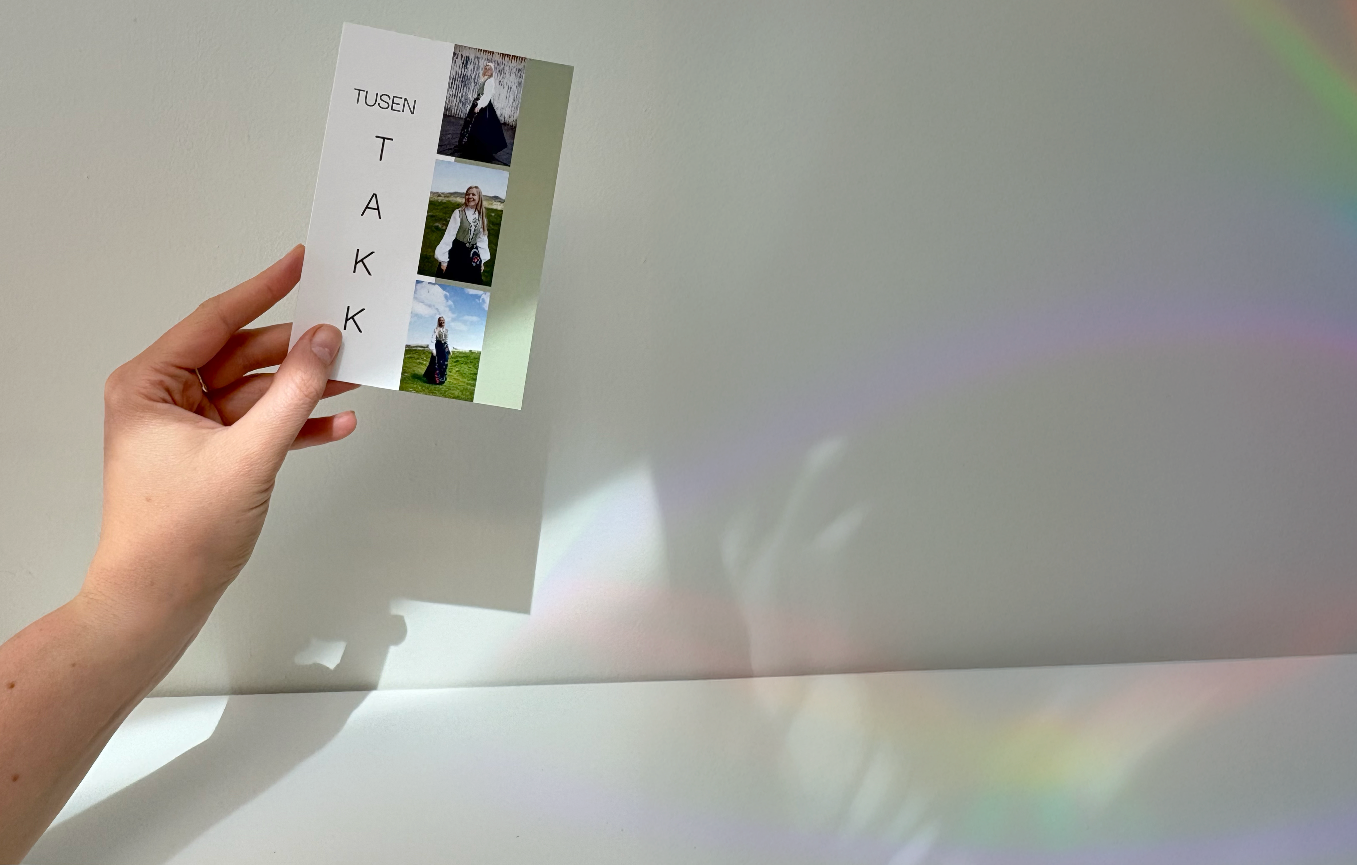 Ett takkekort med delvis grønn bakgrunn, bilder og teksten tusen takk, vises frem